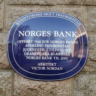 Bilde av et blått metallskilt i Fredrikstad, på Norges Bank