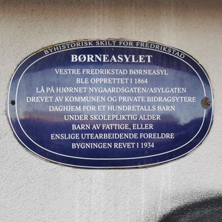 Bilde av et blått metallskilt i Fredrikstad, på det som tidligere var Børneasylet