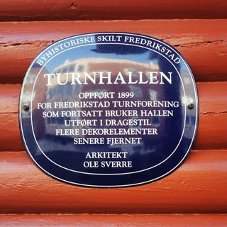 Bilde av et blått metallskilt i Fredrikstad, på Turnhallen